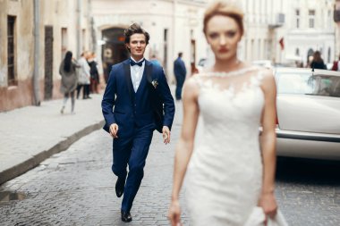 yürüyüş şık gelin ve damat şehir sokak peşinden koşma. ve dans eğlenceli sahip mutlu lüks düğün çifti. romantik an.