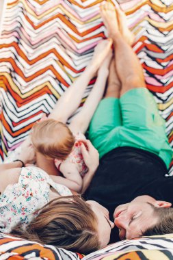 sevimli kızıyla oynayan ve sarılma, akşam güneş ışığı sahilde yaz tatile hamakta rahatlatıcı mutlu şık bir aile. Öpüşme ve gün batımı dinlenme hipster çift. metin için yer