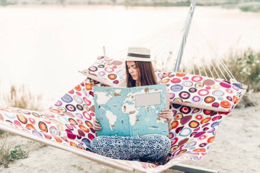 büyük kitap yaz akşam ışığı plajında hamakta rahatlatıcı güzel hippi kız. mutlu kadın dinlenme ve güneşte, yaz tatili okuma hasır şapkalı. metin için yer