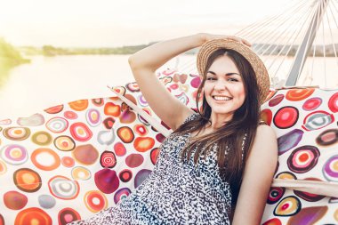 güzel boho hippi kız sahilde yaz akşam ışığı hamakta rahatlatıcı. mutlu kadın dinlenme ve güneş, yaz tatili an zevk hasır şapkalı. metin için yer