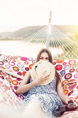 güzel hippi kız sahilde yaz akşam ışığı hamakta rahatlatıcı. mutlu kadın dinlenme ve güneş, yaz tatili an zevk hasır şapkalı. metin için yer