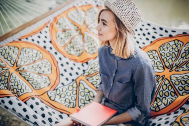 gülümseyen ve gün zevk ormanda kitap ile dinlenme sarışın kız. yaz tatili