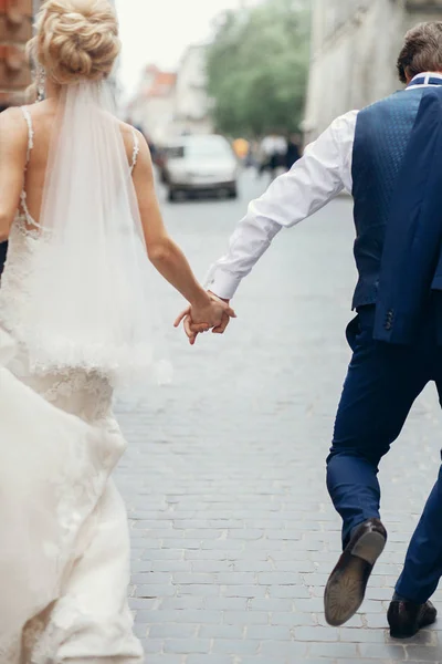 スタイリッシュな花嫁と花婿の街で楽しく踊ったり 幸せな贅沢な結婚式を保持している光の手 ロマンチックな官能的な瞬間 感情的な男と女 — ストック写真