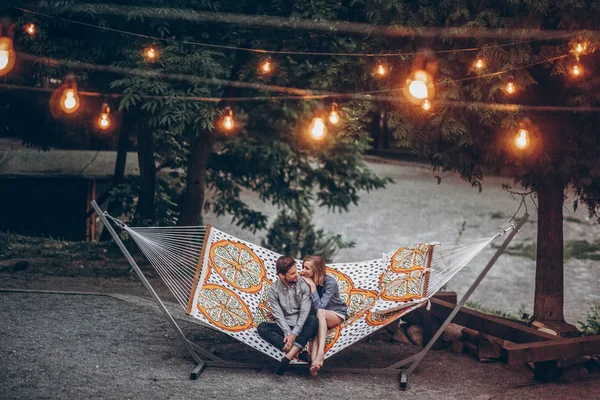 Pareja Hipster Con Estilo Abrazo Relajarse Hamaca Bajo Luces Retro —  Fotos de Stock