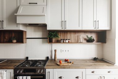 İskandinav tarzı modern mutfak tasarımı. modern mobilya ve paslanmaz çelik aletleri ile şık ışık gri mutfak iç. ahşap tezgah, çelik soba, Yönetim Kurulu, bıçak ve baharatlar