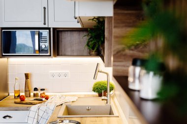 İskandinav tarzı modern mutfak tasarımı. modern mobilya ve paslanmaz çelik aletleri ile şık ışık gri mutfak iç. ahşap tezgah, çelik soba, Yönetim Kurulu, bıçak ve baharatlar