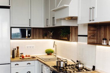 İskandinav tarzı modern mutfak tasarımı. modern mobilya ve paslanmaz çelik aletleri ile şık ışık gri mutfak iç. ahşap tezgah, çelik soba, Yönetim Kurulu, bıçak ve baharatlar
