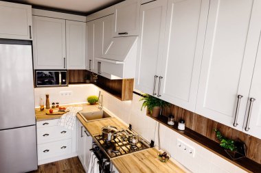 İskandinav tarzı modern mutfak tasarımı. modern mobilya ve paslanmaz çelik aletleri ile şık ışık gri mutfak iç. ahşap tezgah, çelik soba, Yönetim Kurulu, bıçak ve baharatlar
