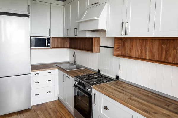 Şık ışık gri mutfak iç modern dolaplar ve paslanmaz çelik araçlarla bir lüks yeni evde. İskandinav tarzı mutfak tasarımı.