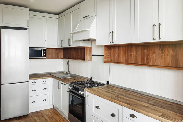 スタイリッシュな明るい灰色キッチン インテリア モダンなキャビネット ステンレス製の電化製品 北欧風のキッチン デザイン 堅木張りの床と木製のワークトップ 花崗岩のシンクとスタイリッシュな蛇口 — ストック写真