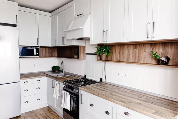 现代斯堪的纳维亚风格的厨房设计 时尚的浅灰色厨房内饰与现代家具和不锈钢家电在一个新的房子 木台面 钢制火炉 水槽和水龙头 — 图库照片