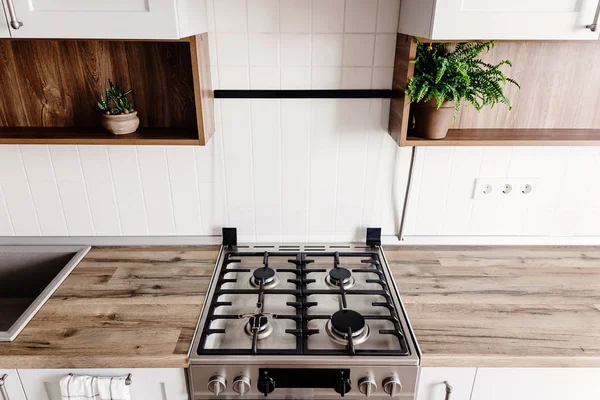 yakın çekim çelik yeni bir ev mobilya ve paslanmaz çelik aletleri ile modern şık ışık gri mutfak iç soba. ahşap tezgah, çelik tencere, bitkiler