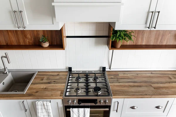 スタイリッシュな明るい灰色キッチン インテリア モダンなキャビネットと新しい家でステンレス製の電化製品 北欧スタイルをデザインします 緑の植物の装飾 木製ワークトップ シンク コンロ — ストック写真