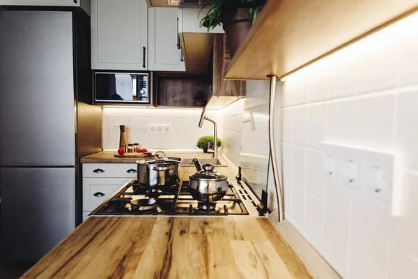 Modern mutfak İskandinav tarzı yemek. modern mobilya ve paslanmaz çelik aletleri ile şık mutfak iç. ahşap tezgah, çelik soba, Masa, bıçak ve baharat, domates