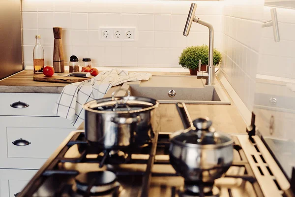 Modern mutfak İskandinav tarzı yemek. modern mobilya ve paslanmaz çelik aletleri ile şık mutfak iç. ahşap tezgah, çelik soba, Masa, bıçak ve baharat, domates