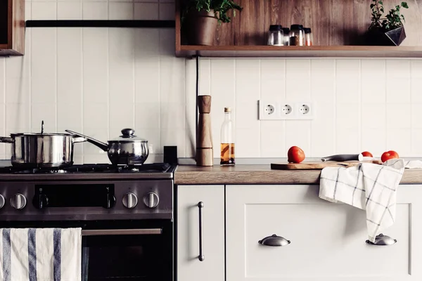 在斯堪的纳维亚风格的现代厨房烹饪 时尚的厨房内饰与现代家具和不锈钢器具 木台面 刀和香料 西红柿 — 图库照片