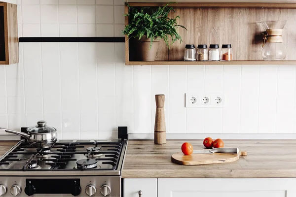 在斯堪的纳维亚风格的现代厨房烹饪 时尚的灰色厨房室内设计与现代家具和不锈钢器具 木制台面 刀和香料 — 图库照片