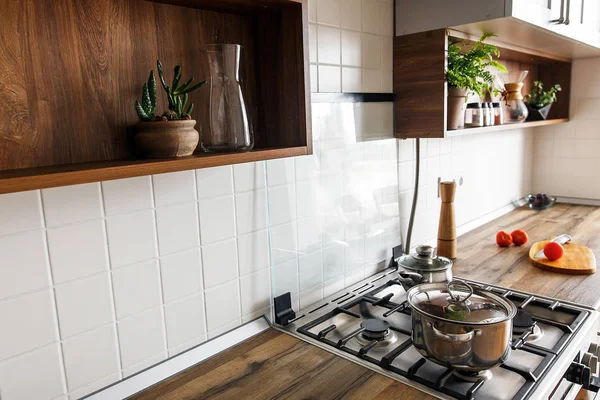 烹调食物 木板与刀 西红柿 橄榄油在现代厨房台面和钢火炉与平底锅 时尚的灰色厨房室内设计斯堪的纳维亚风格 — 图库照片