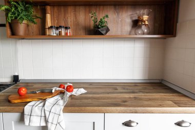 Ahşap tahta bıçak, modern mutfak tezgah ve raflar cam kavanoz içinde maddeler baharatlar ile domates ile. yemek yemek. İskandinav tarzı şık gri mutfak dekorasyon