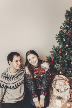 şık hipster kaç sarılma ve Noel ağacının rahat akşam odada kucaklayan kazak içinde. atmosferik anlar. mutlu Noeller ve mutlu yeni yıl kavramı. İyi Bayramlar