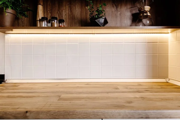 时尚的厨房内饰与现代橱柜和木台面下灯和货架上的香料在一个豪华的新房子 斯堪的纳维亚风格的厨房设计 — 图库照片