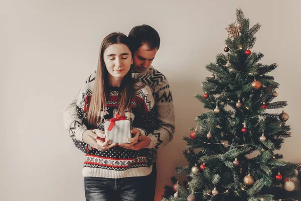 mutlu Noeller ve mutlu yeni yıl kavramı. şık hipster çift hediyeler Noel ağacı ışıkları, metin için yer altında Festival odasında alışverişi. İyi Bayramlar. Aile atmosferik anlar