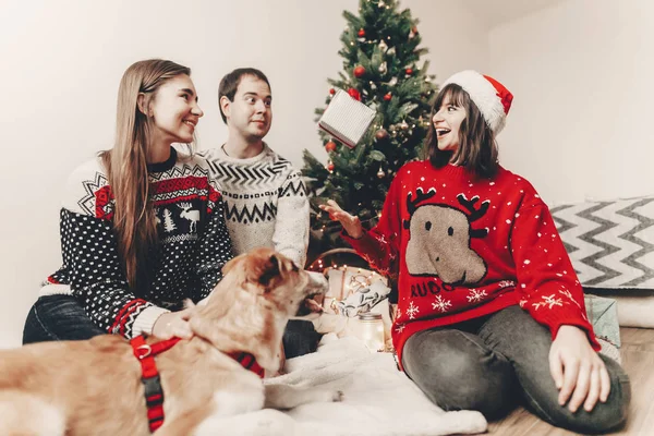 mutlu Noeller ve mutlu yeni yıl kavramı. şık hipster ailesinde Hediyelik Noel ağacı ışıkları kadar sevimli köpek savurma ile şenlikli kazak. İyi Bayramlar. komik duygusal anlar