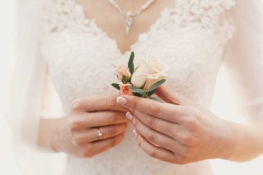 şık basit yaka çiçeği pahalı gümüş kolye inci ve gelinlik ile arka planda elinde tutan güzel gelin. Gelin sabah hazırlıkları