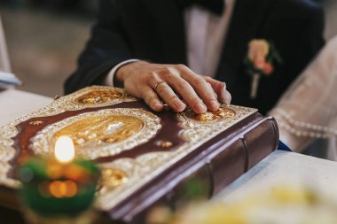 Gelin ve damat altın İncil'in üzerine kutsal sunak üzerinde kilise, düğün töreni sırasında elele yeminleri alışverişi. Kutsal evlilik bağıyla manevi anları