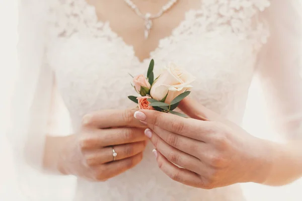 高価な銀のネックレス真珠とウェディング ドレスの背景に手でスタイリッシュなシンプルなブートニアを保持して美しい花嫁 朝の準備 — ストック写真