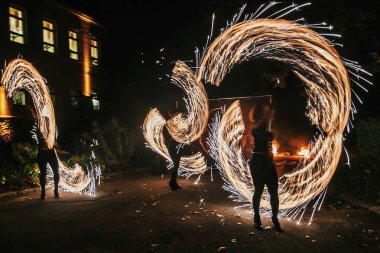 Yangın gösteri festivalinde geceleri şaşırtıcı veya parti düğün. Yangın dansçılar swing, iplik ateş ve gece ile parlak kıvılcımlar hokkabazlık adam. ateş gösterisi performansını ve eğlence
