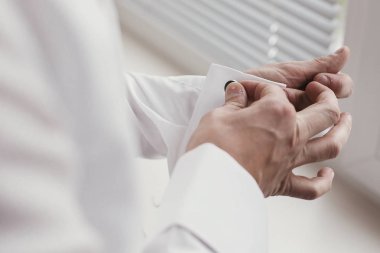 Damat odaya sabah hazırlanıyor. adam kol düğmeleri, otel ışık penceresinde ayakta tutan eller. Düğün günü için hazırlık