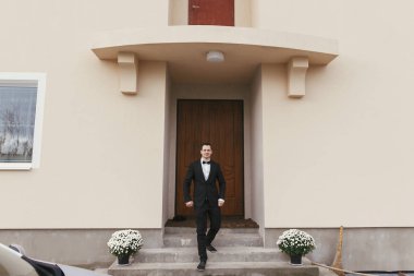 yakışıklı damat evinden aşağı lüks otelde sabahları yürüyüş. mutlu bir adam portresi takım elbiseli. Düğün günü için hazırlık