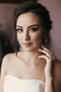 Lüks küpe üzerinde koyarak muhteşem gelin. güzel bir kadın portresi düğün için hazırlanıyor. duygusal bir an. seksi kız poz. Düğün takı aksesuar