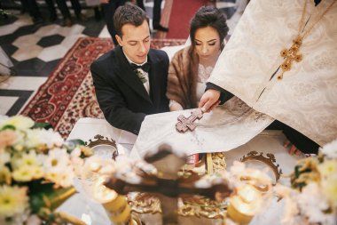 Gelin ve damat sözü telaffuz altar ve altın tutarak rahip İncil'e el ele tutuşarak ellerde kilise kutsal evlilik bağıyla sırasında çapraz