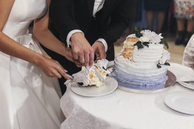 muhteşem gelin ve şık damat düğün resepsiyon restoran onların şık düğün pastası çiçek dekorasyonu ile kesme. mutlu yeni evli çift duygusal anlar