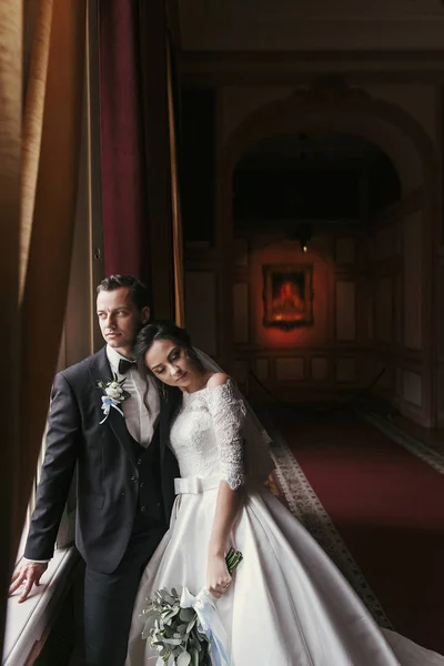 Nádherná Nevěsta Úžasné Šaty Kyticí Stylový Ženicha Pózuje Okna Luxusně — Stock fotografie