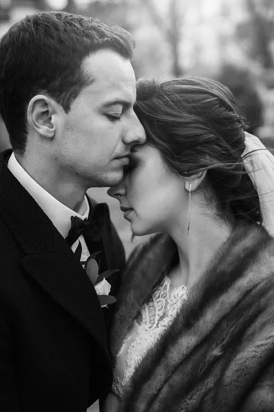ゴージャスな花嫁の花束と秋の時間でヨーロッパの街で優しく抱き締めるスタイリッシュな新郎 幸せの結婚式を採用します 新婚夫婦のロマンチックな官能的な瞬間 — ストック写真