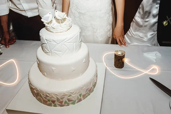 Stylish gorgeous unusual white wedding cake with geometry concept and birds. Unique delicious sweet