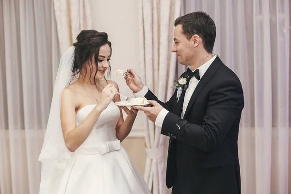 豪華なレストランでの結婚披露宴で スタイリッシュなウェディング ケーキの試飲スタイリッシュな新郎新婦 幸せな新婚カップル食べるケーキの作品 面白い感動的な瞬間 — ストック写真