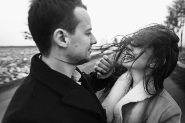 rüzgarlı saç ve damat yolda kucaklayan şehvetli gelinle. mutlu çift, sarılma ve öpüşme rüzgarda romantik ihale ve cinsel an duygusal çift düğün.