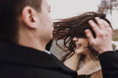 rüzgarlı saç ve damat yolda kucaklayan şehvetli gelinle. mutlu çift, sarılma ve öpüşme rüzgarda romantik ihale ve cinsel an duygusal çift düğün.