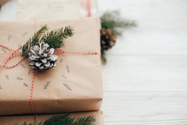 Noel şık hediyelerle kırmızı kurdele, şeker kamışı, Çamın dalları, koniler. kopya alanı. Beyaz ahşap zemin üzerinde modern craft hediyeler. mevsimlik tebrik kartı mock-up.