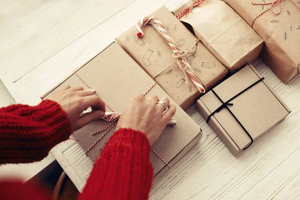 şık basit Noel hediyesi Kırmızı bornoz ile kaydırma kırmızı kazaklı kadın. Modern craft Beyaz ahşap arka plan üzerinde sunuyor. neşeli Noel kavramı. mevsimlik selamlar