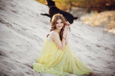 yakın göl günbatımı ışıkta kum plajındaki oturan güzel boho kız