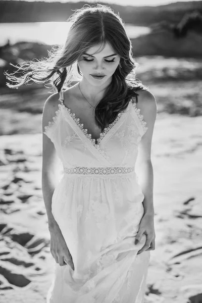 rüzgarlı saç konumu kum plajındaki tek renkli olan beyaz bohem içinde çekici genç kadın