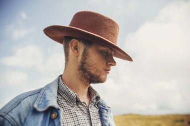 şık seyahat adam şapka ayakta güneşli dağlar bulutların üstüne sakallı. metin için yer. hipster kovboy adam portresi. muhteşem atmosferik an. seyahat ve Yolculuk tutkusu