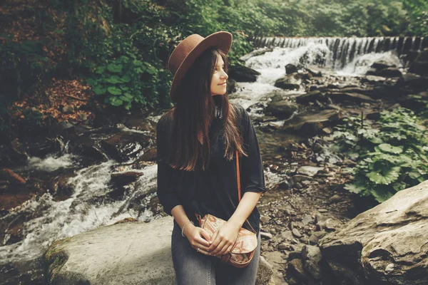 Stilvolles Mädchen Mit Hut Sitzt Wasserfall Fluss Sonnigen Wald Sommerferien — Stockfoto