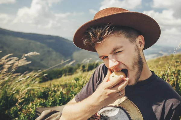 Viajero Elegante Hombre Sombrero Comer Manzana Cima Las Montañas Soleadas — Foto de Stock