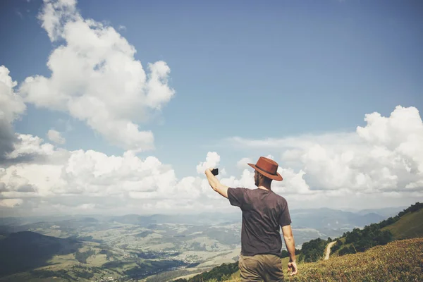 Dumdum Mężczyzna Kapeluszu Trzymając Telefon Chodzenie Szczycie Góry Słoneczny Niebo — Zdjęcie stockowe